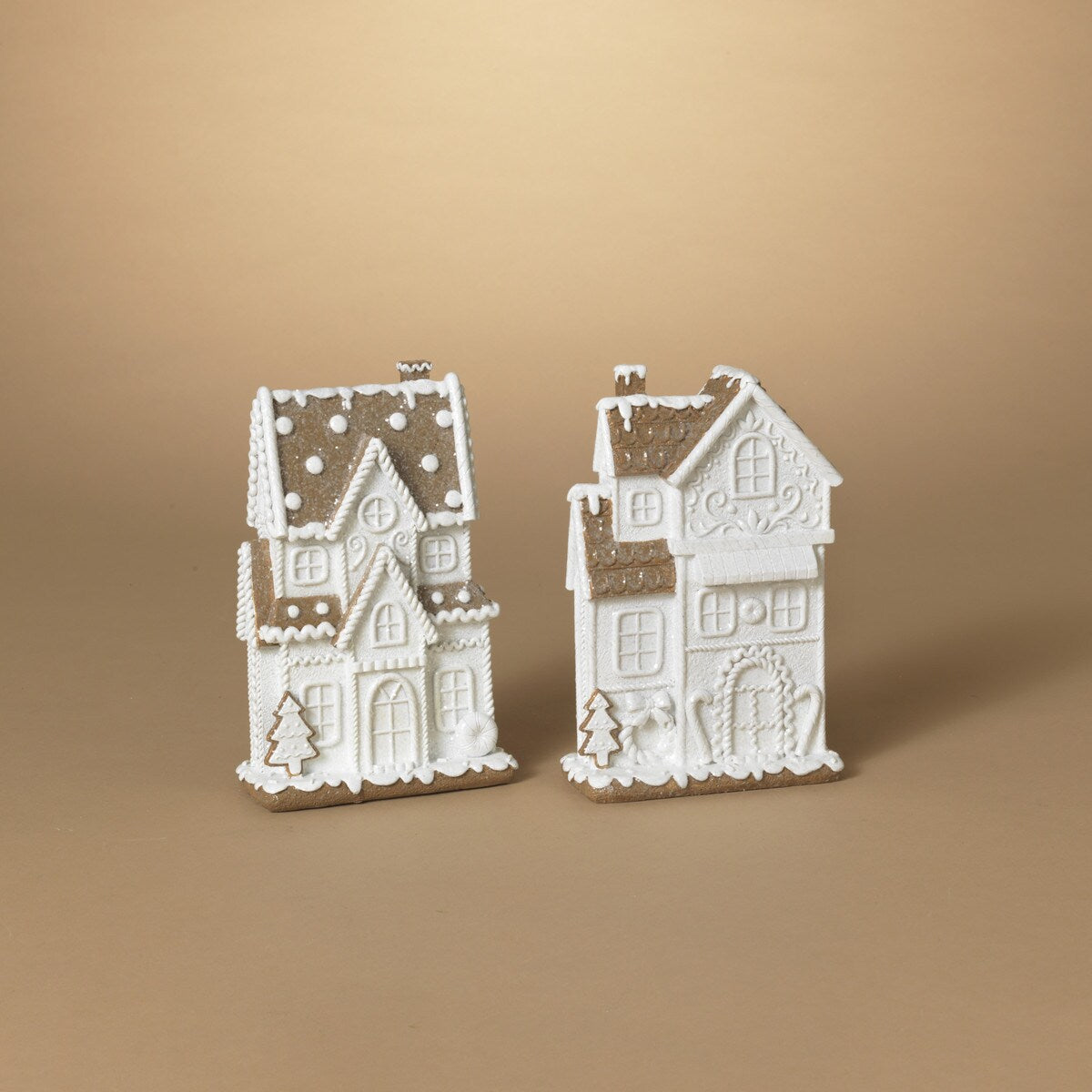 Two white resin gingerbread houses with brown roofs and decorative elements, displayed against a neutral background.