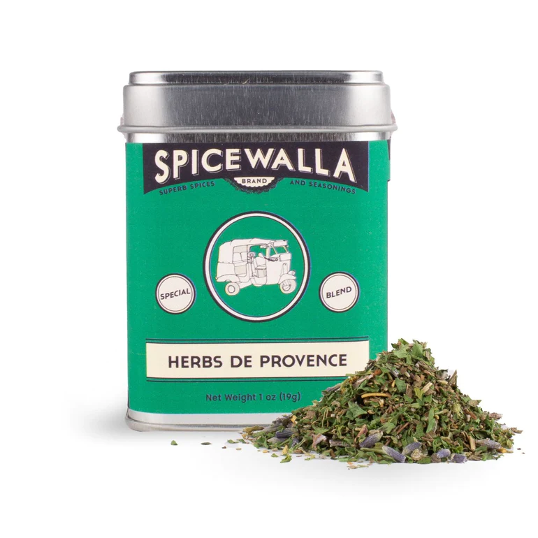 A tin labeled 'Spicewalla Herbs de Provence' with a pile of dried herbs in front of it, indicating the product is a seasoning blend.