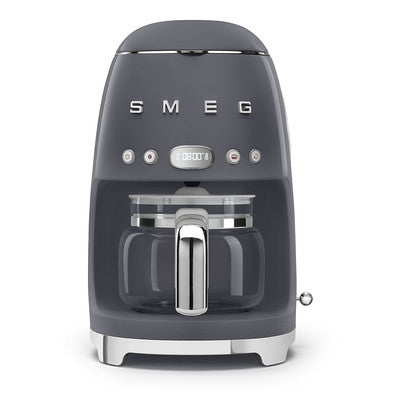 A green SMEG drip filter coffee machine with a glass carafe and stainless steel accents.