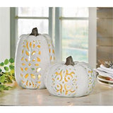 Two ceramic pumpkin lanterns with cut-out leaf patterns, one tall and one small, displayed on a surface.