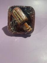 A wooden mini scoop with a pinch bowl set, placed on a clear plastic wrapping against a purple background.