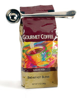 A silver coffee scoop is placed on top of a coffee bag labeled 'Gourmet Coffee - Breakfast Blend'.