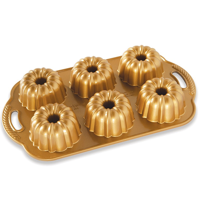 A set of gold-colored bundtlette pans with a tray, used for baking individual cakes.
