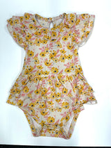 A baby onesie with a floral pattern featuring daisies in yellow and pink colors on a beige background.