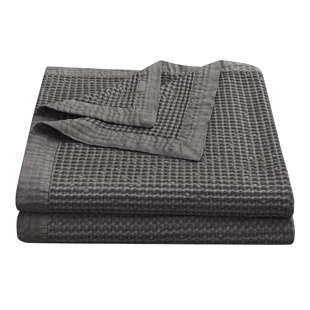 A folded gray cotton coverlet with a waffle weave pattern on a white background.