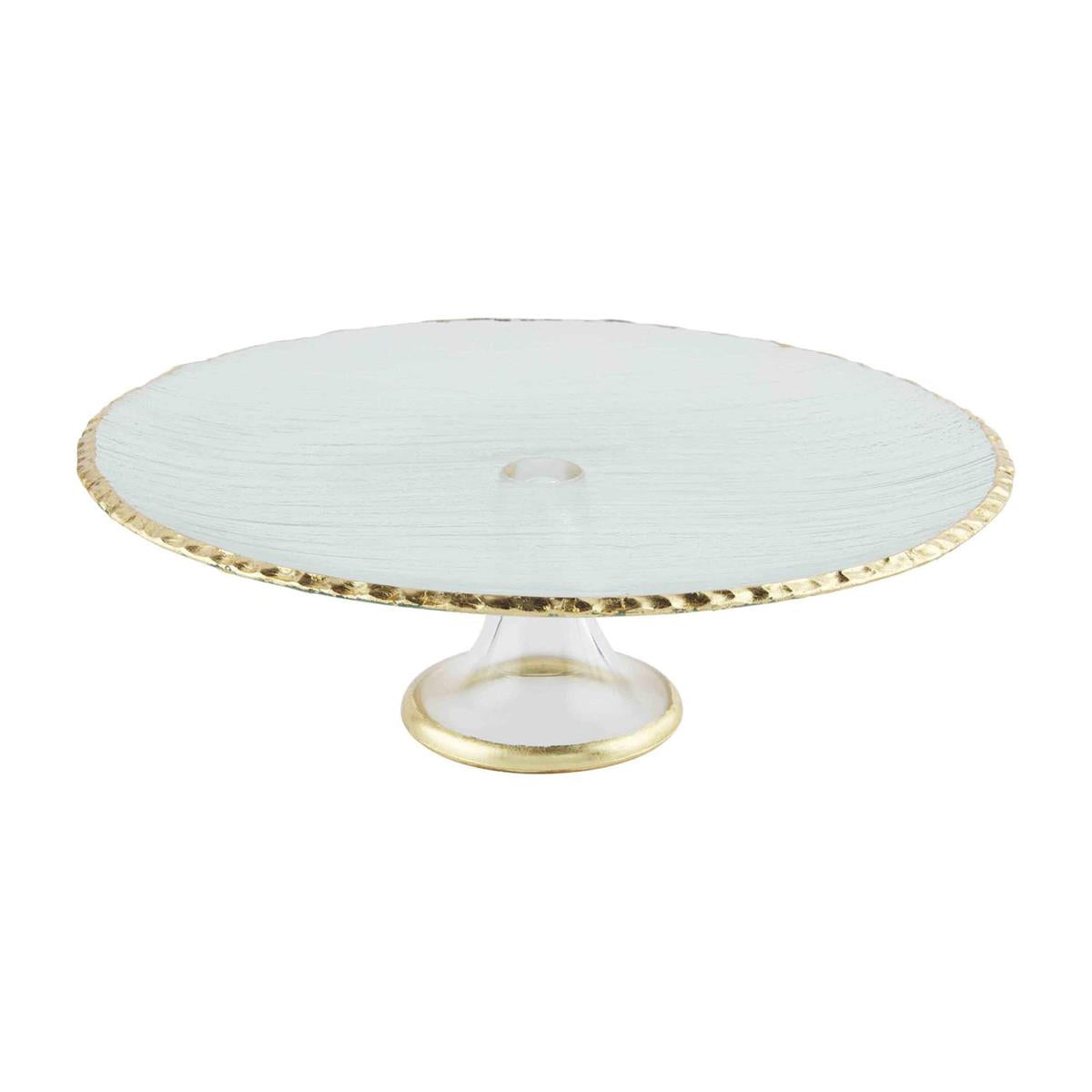 A gold cake stand with a white cake on top and a golden circular base.