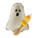 A beige ceramic candy bowl shaped like a ghost with a wooden spoon and candy corn design, against a white background.