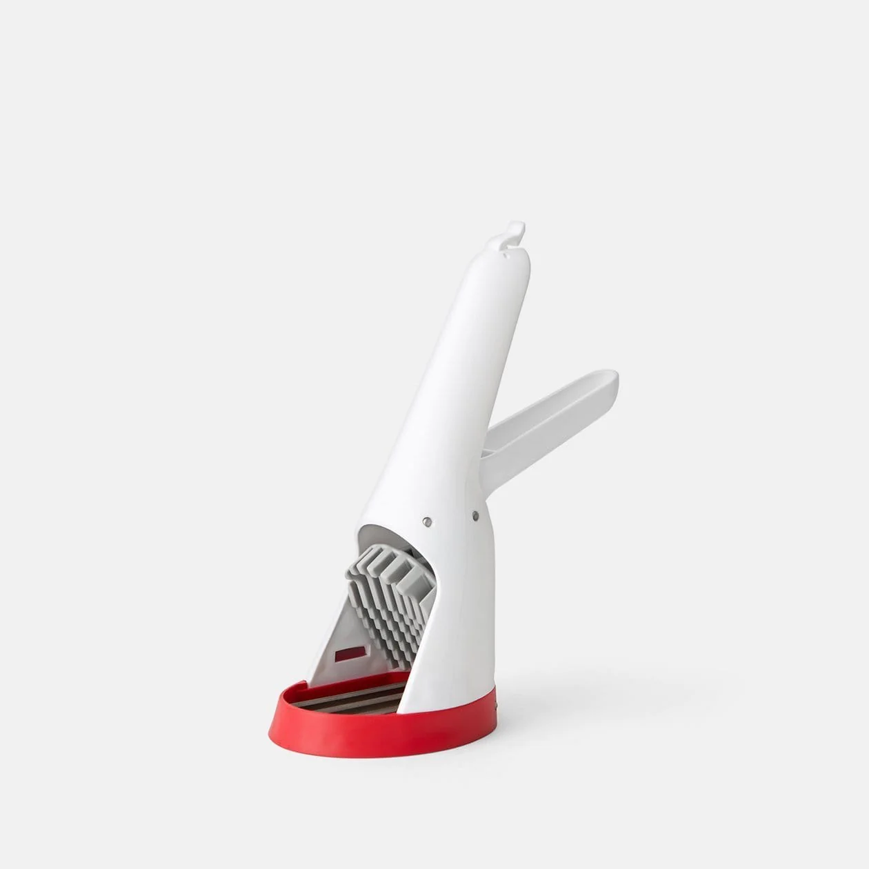 A white strawberry slicer with a red accent and a serrated wheel.